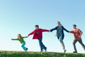 Parents and two children running and holding hands